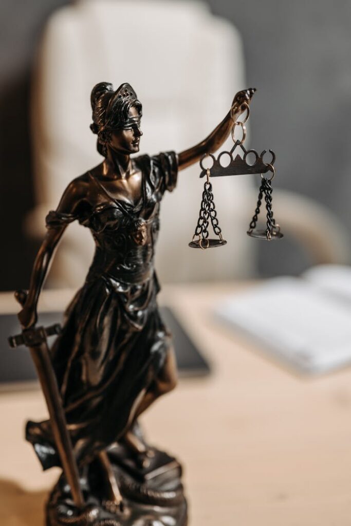 Bronze Lady Justice statue with scales and sword, symbolizing fairness and law.